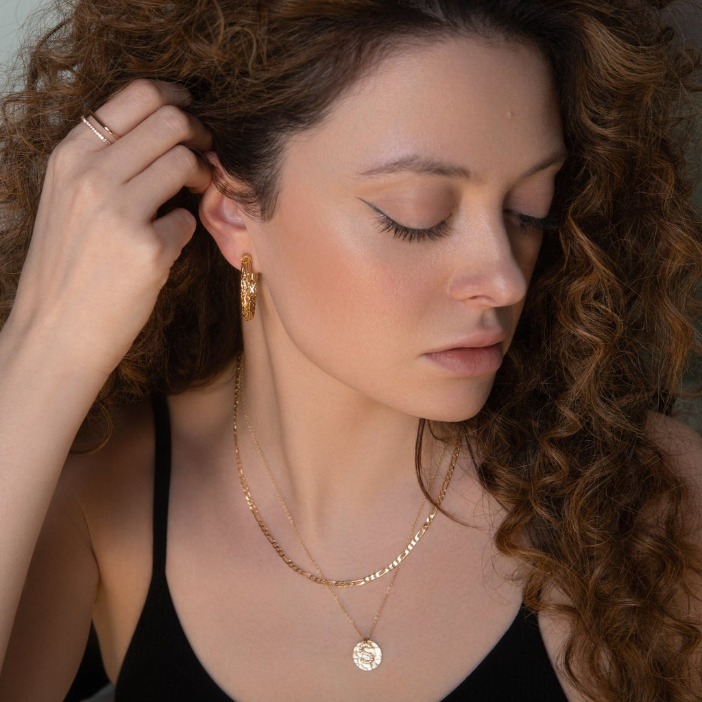 model wearing a square shaped geometric gold and crystal ring