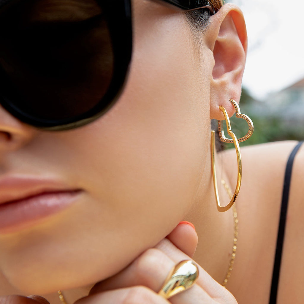 model wears Gold oversized Heart Hoop Earrings