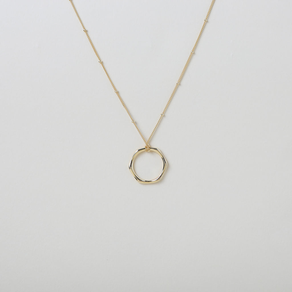 Gold hexagon pendant on a micro bead accented gold chain