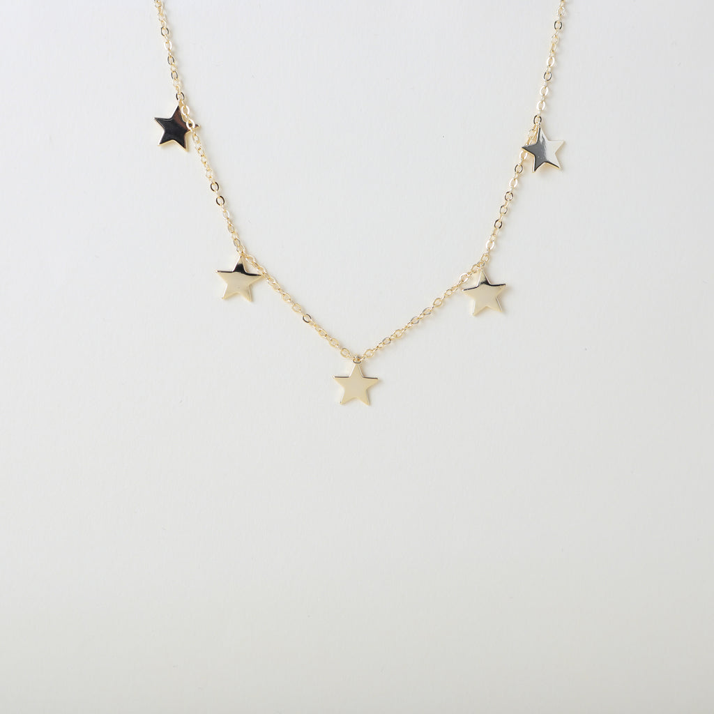 Gold star lined necklace with five stars placed at intervals along the chain