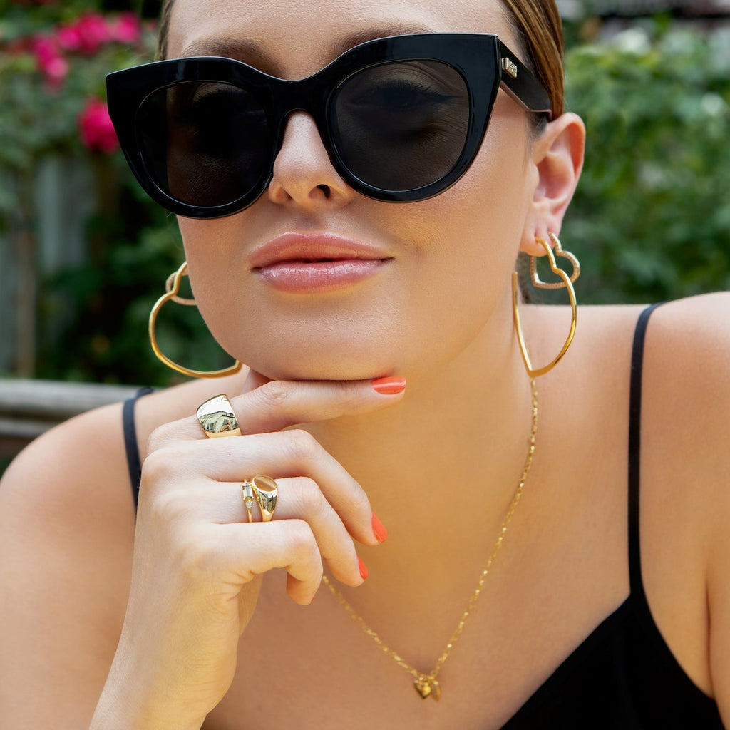 Model wears Gold oversized Heart Hoop Earrings